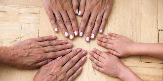 different generations of a family touching hands