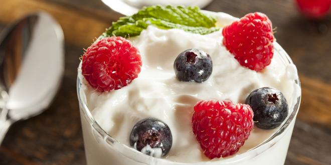 a close-up of a creamy parfait topped with berries