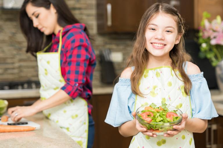 A girl holding a fresh made salad.