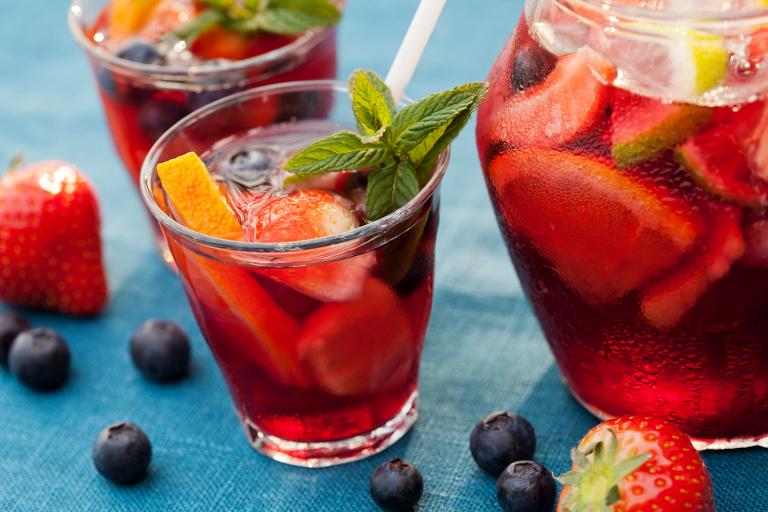 a sparkling punch mocktail with cut fruit and garnish